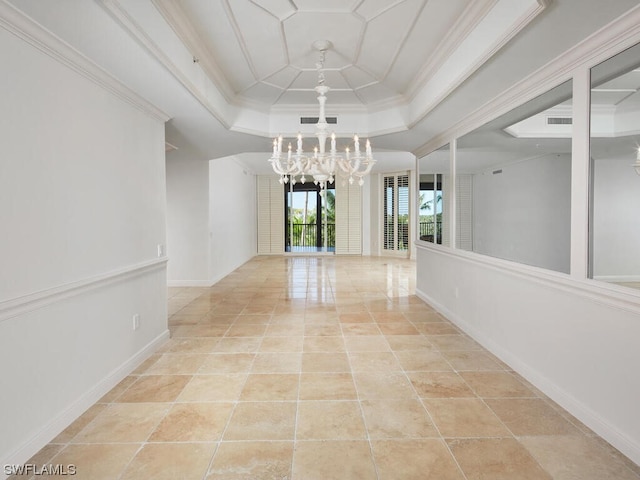 empty room with baseboards, ornamental molding, tile patterned floors, a tray ceiling, and an inviting chandelier