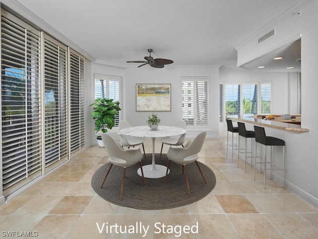 tiled dining space with plenty of natural light, crown molding, and ceiling fan