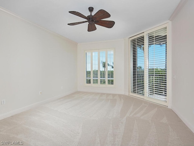 unfurnished room featuring light colored carpet, ornamental molding, and ceiling fan