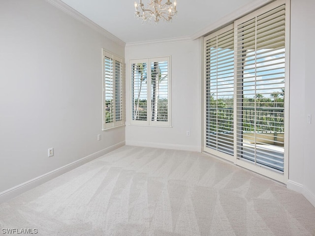 spare room with light carpet, ornamental molding, and an inviting chandelier