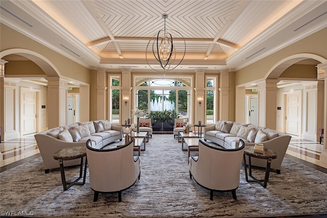 living room featuring a notable chandelier, ornate columns, coffered ceiling, and ornamental molding