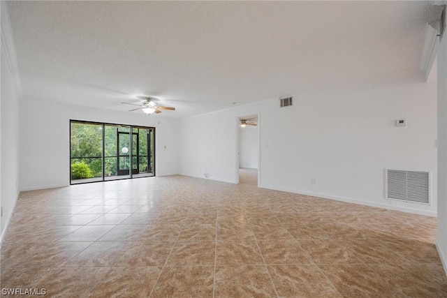 empty room featuring ceiling fan, a textured ceiling, visible vents, and baseboards