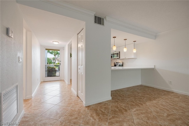 hallway featuring crown molding and light tile patterned floors