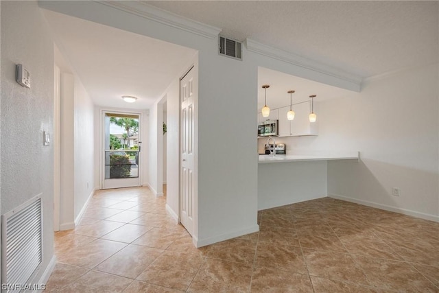 hallway featuring light tile patterned flooring, baseboards, visible vents, and ornamental molding