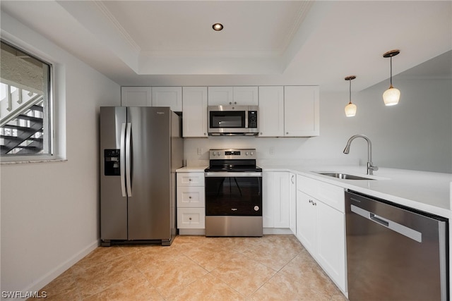 kitchen with appliances with stainless steel finishes, white cabinets, sink, and a tray ceiling