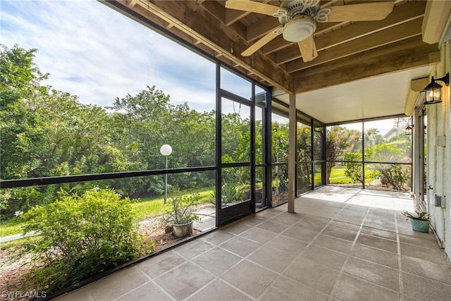 unfurnished sunroom featuring ceiling fan