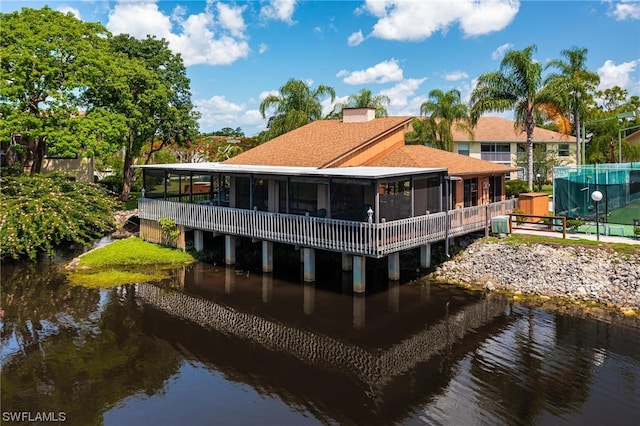 back of house with a sunroom and a water view