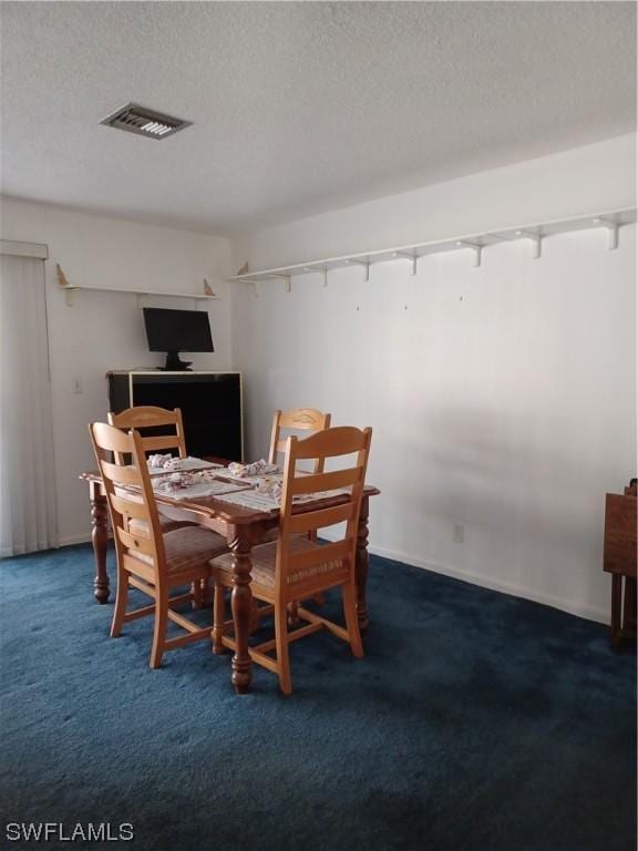 carpeted dining space featuring a textured ceiling