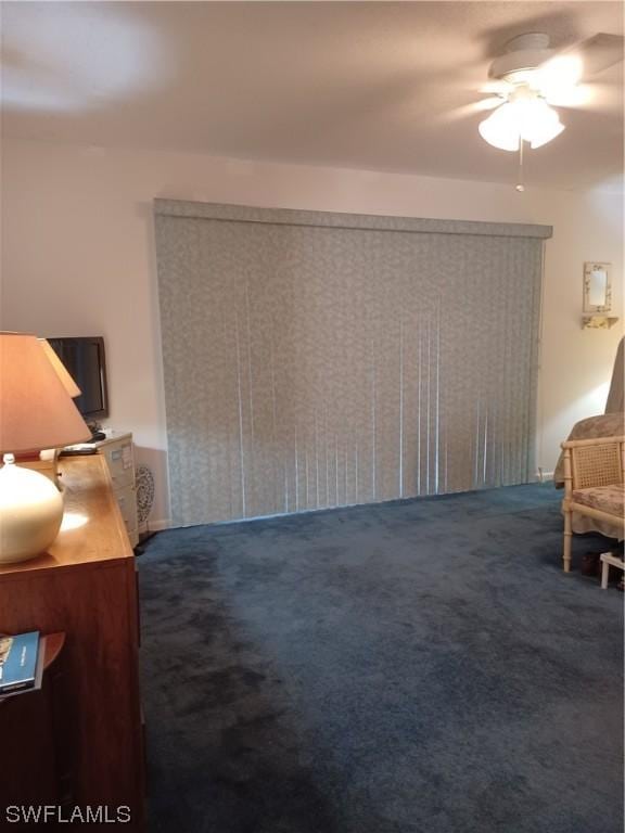 sitting room with dark colored carpet and ceiling fan