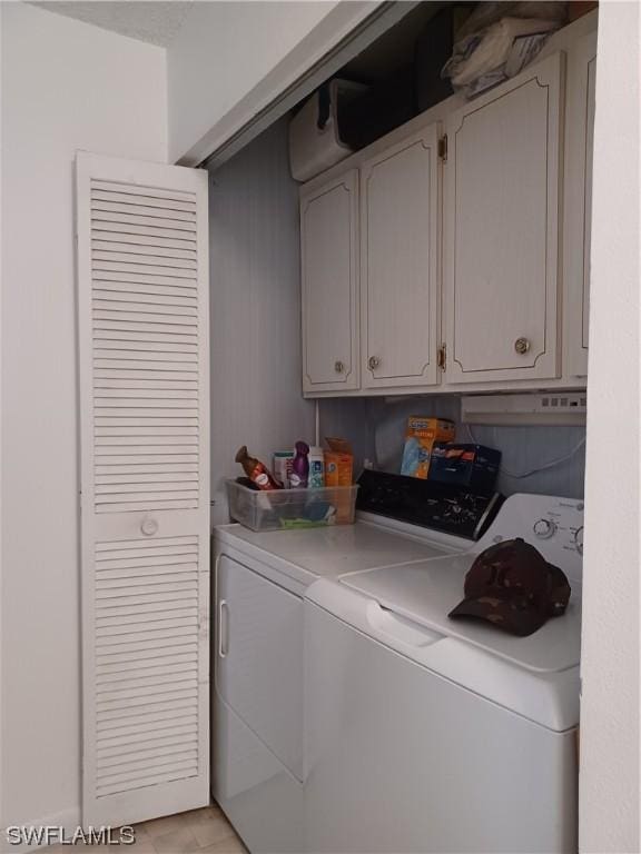 laundry area with separate washer and dryer and cabinets