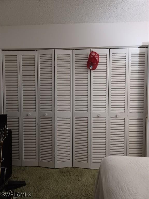 bedroom with a textured ceiling and a closet