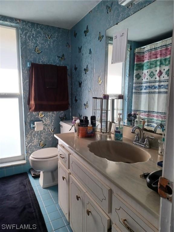 bathroom with tile patterned flooring, vanity, and toilet