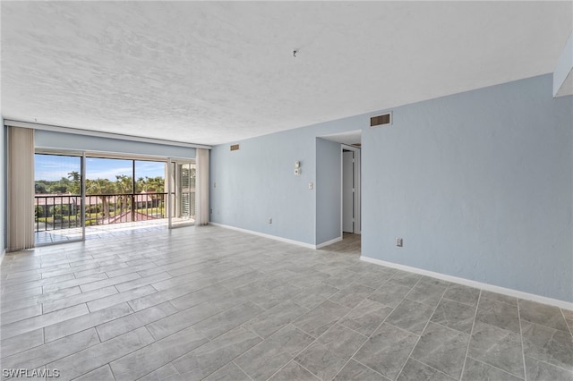 unfurnished room with a textured ceiling