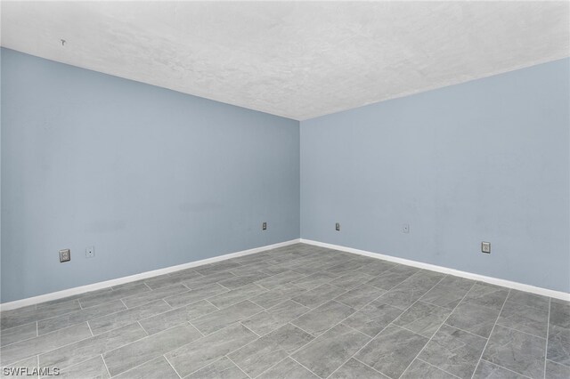 unfurnished room with a textured ceiling