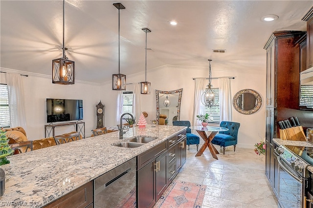 kitchen with appliances with stainless steel finishes, light stone counters, vaulted ceiling, sink, and pendant lighting