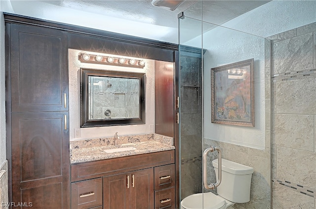 bathroom with vanity, toilet, and tile walls