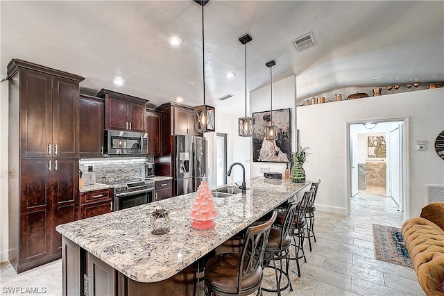 kitchen featuring sink, an island with sink, pendant lighting, and appliances with stainless steel finishes