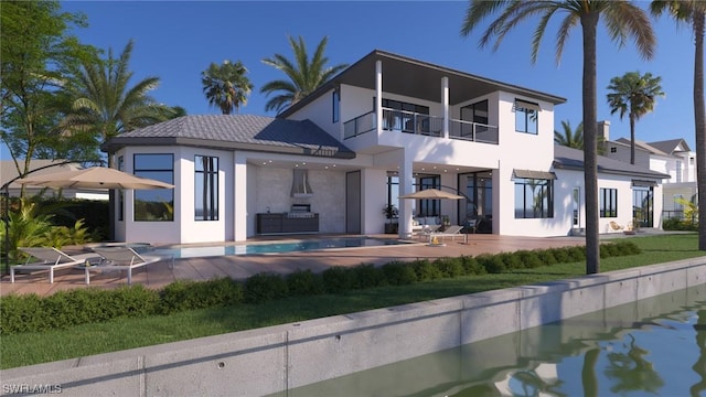 rear view of property featuring a balcony and a patio area