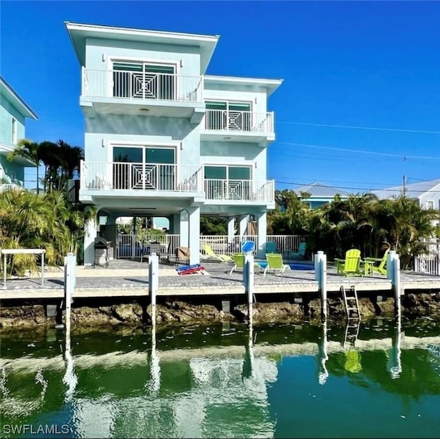 rear view of house featuring a water view and fence