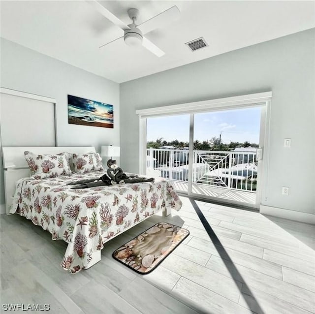 bedroom featuring ceiling fan, wood finished floors, visible vents, baseboards, and access to outside