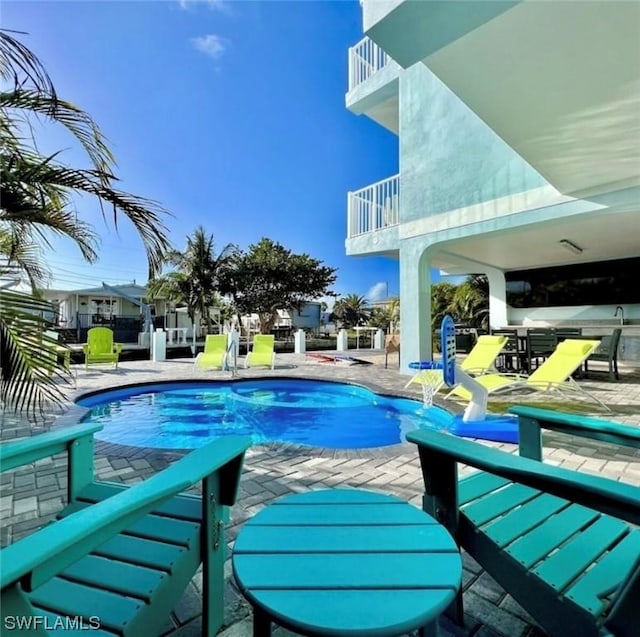 view of swimming pool featuring a pool with connected hot tub and a patio