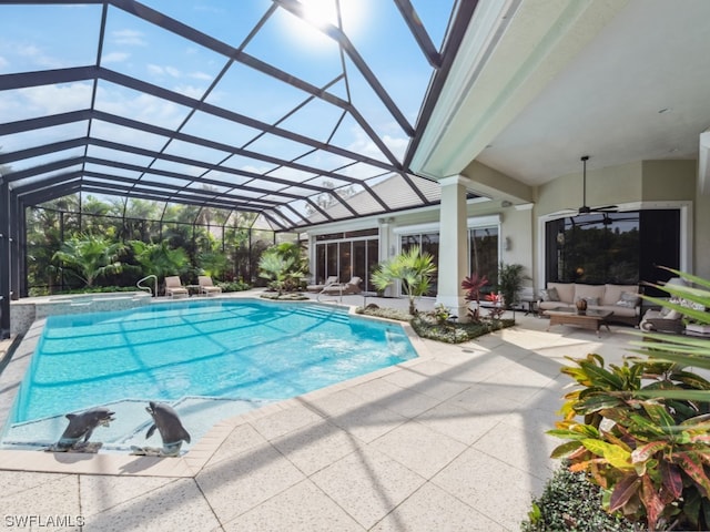 view of swimming pool featuring outdoor lounge area, glass enclosure, ceiling fan, and a patio area