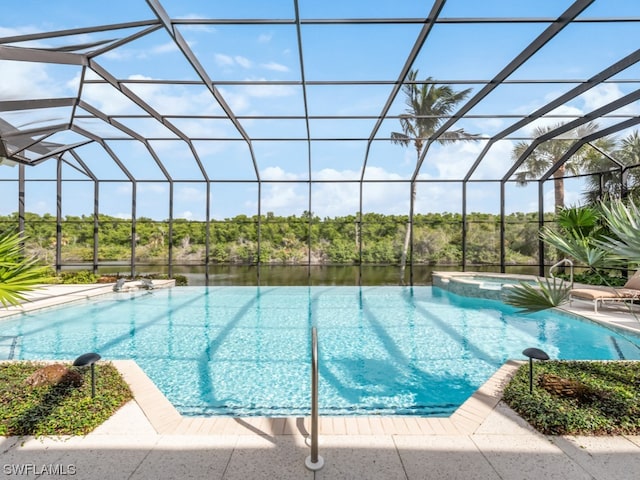 view of swimming pool featuring an in ground hot tub, a water view, and glass enclosure