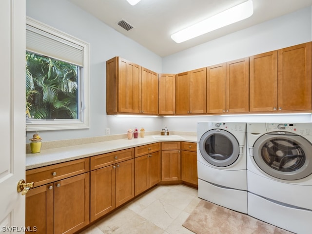 clothes washing area featuring washer and dryer, sink, and cabinets