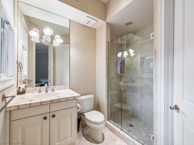 bathroom with tile patterned floors, vanity, toilet, and an enclosed shower