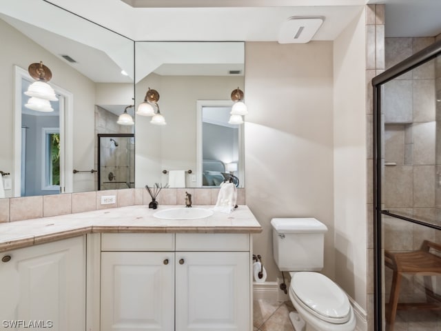 bathroom with vanity, toilet, a shower with shower door, and tile patterned flooring