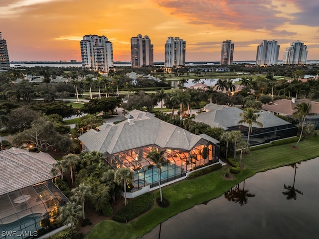 aerial view at dusk featuring a water view