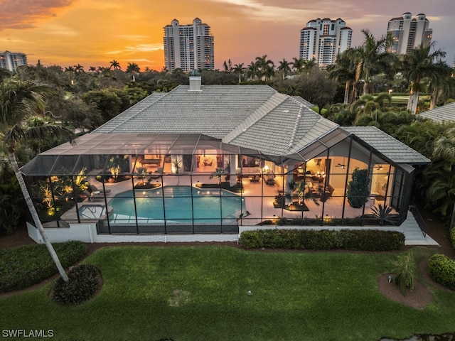 pool at dusk featuring a yard and a patio