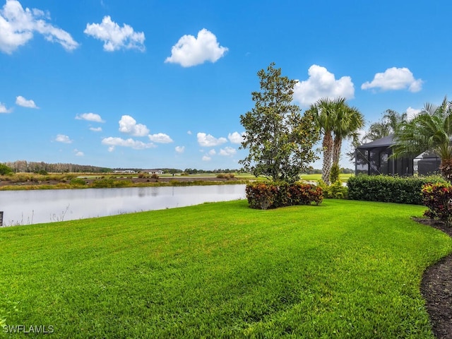 view of yard featuring a lanai and a water view