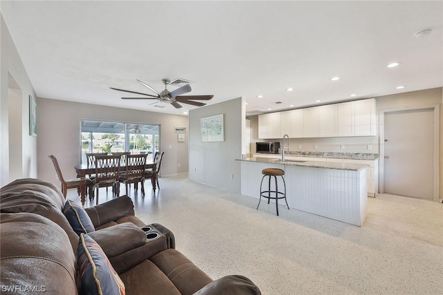 living room with ceiling fan and sink