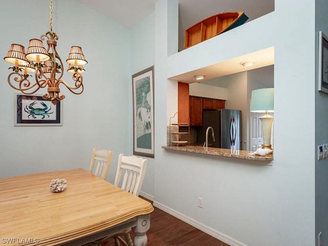 dining room with dark hardwood / wood-style flooring and an inviting chandelier