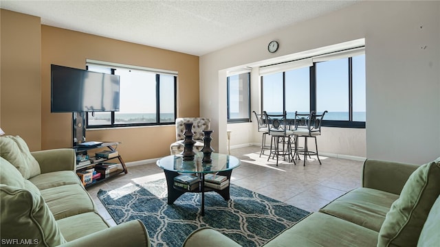 6672 Estero Blvd Unit A409, Fort Myers Beach, FL 33931 - living room with a water view, light tile patterned floors, a textured ceiling, and a wealth of natural light