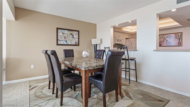 6672 Estero Blvd Unit A409, Fort Myers Beach, FL 33931 - dining area featuring a textured ceiling and a tray ceiling
