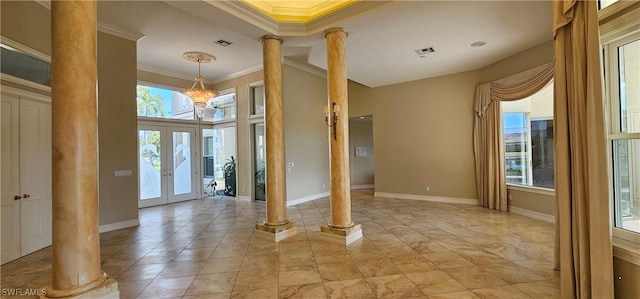 interior space with ornamental molding, french doors, ornate columns, and a healthy amount of sunlight