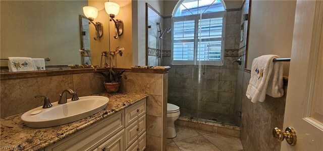 bathroom with a shower with door, tile patterned flooring, toilet, vanity, and decorative backsplash