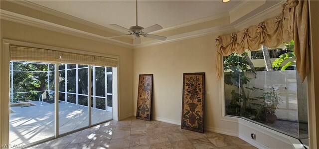 doorway to outside featuring a tray ceiling, ornamental molding, and ceiling fan