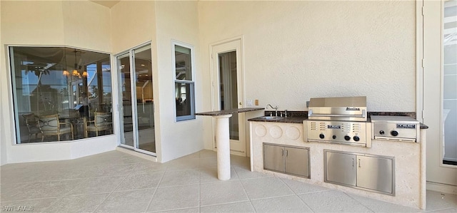 view of patio featuring an outdoor kitchen, area for grilling, and sink