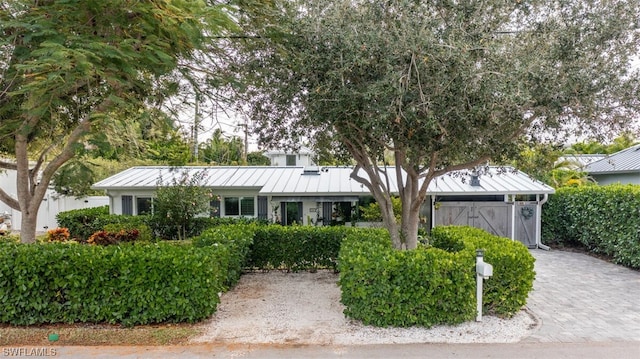 ranch-style home featuring a standing seam roof and metal roof