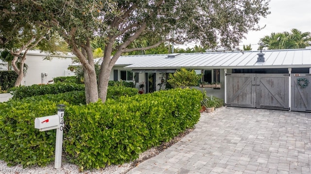 ranch-style home featuring an outbuilding, a standing seam roof, and metal roof