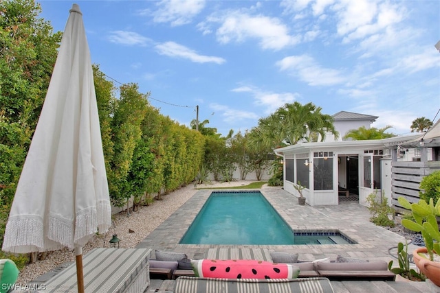 outdoor pool with a sunroom, a fenced backyard, and a patio