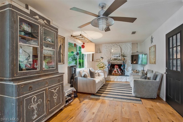 sitting room featuring visible vents, light wood-style flooring, and a ceiling fan