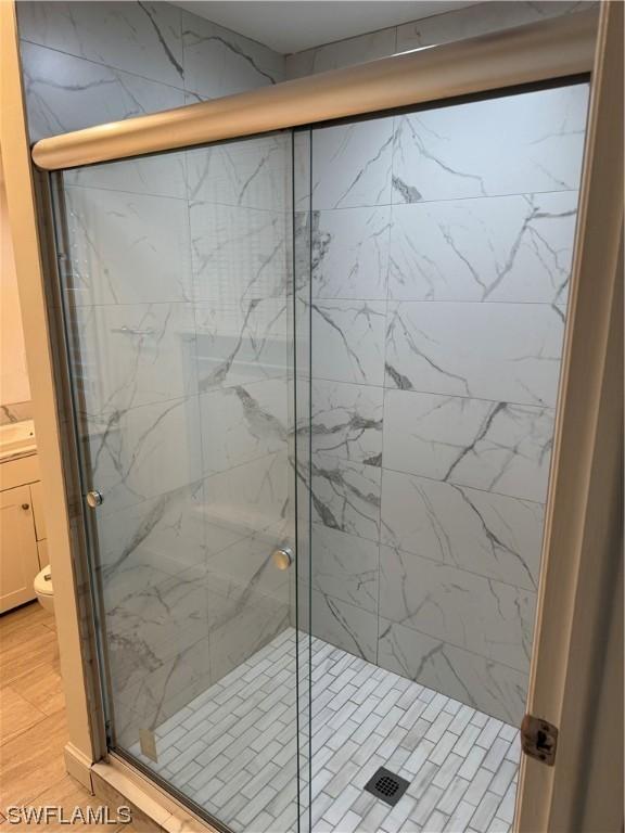 bathroom with walk in shower and hardwood / wood-style flooring