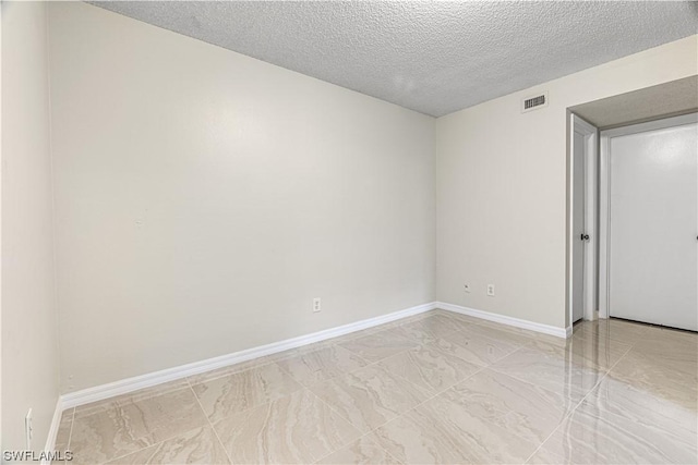 unfurnished room featuring a textured ceiling