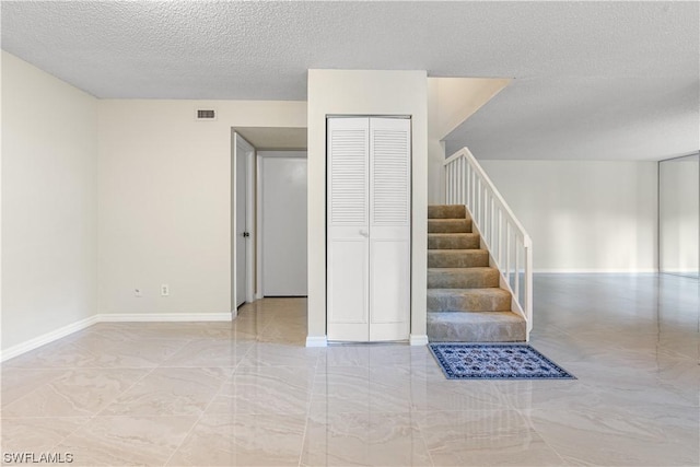 staircase with a textured ceiling