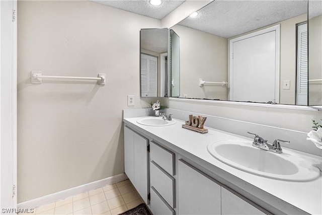 bathroom featuring tile patterned floors, vanity, and a textured ceiling