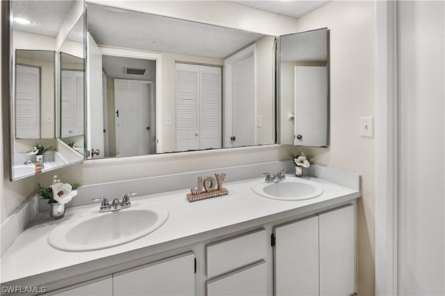 bathroom featuring a textured ceiling and vanity